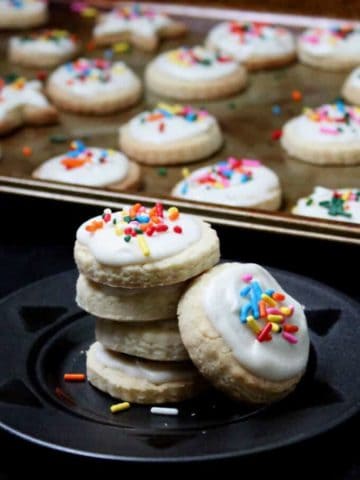 These gluten-free and vegan Sugar Cookies are tender and delicious with a fluffy buttercream-like frosting. Make these a part of your holiday cookie platter. #vegan #soyfree #glutenfree #cookies #recipe #holidays HolyCowVegan.net