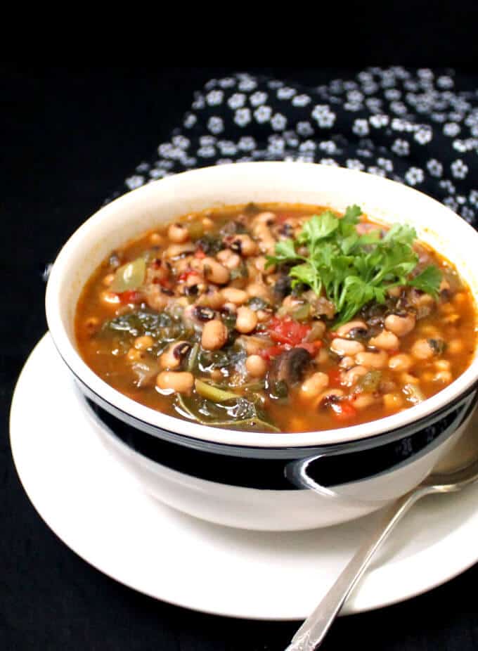 Vegan Instant Pot Spicy Southern Black Eyed Peas Stew in a large bowl with a spoon on the side.