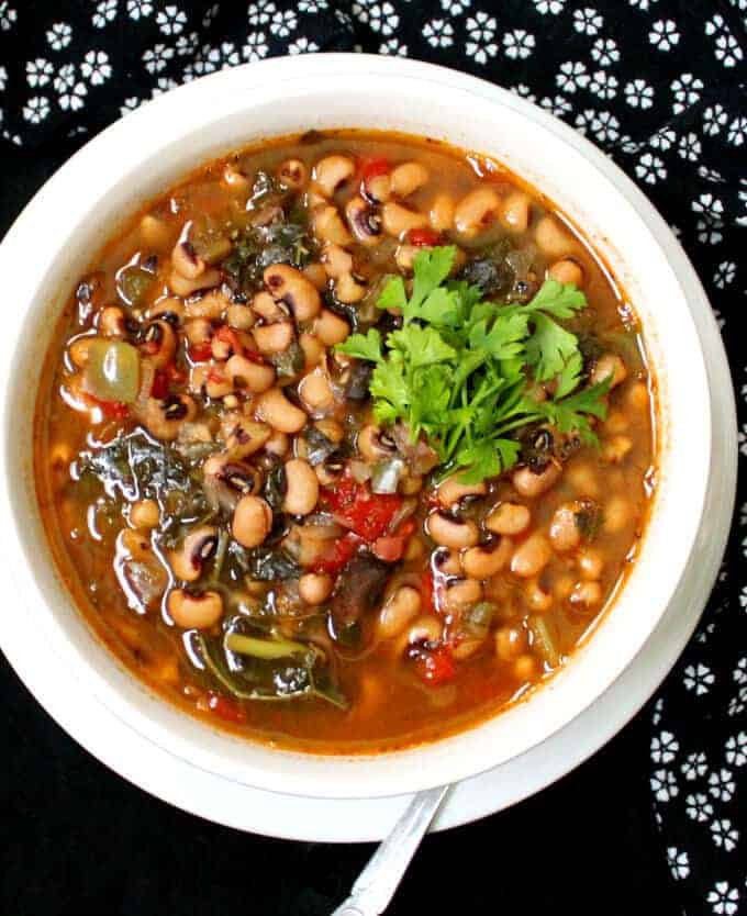 A bowl of vegan Instant Pot Spicy Southern Black Eyed Peas Stew with a spoon.