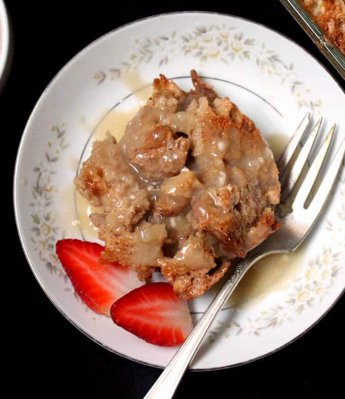 Vegan Fruity Bread Pudding in plate with berries and fork.