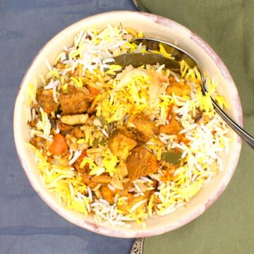 Vegetable biryani in bowl with spoon.