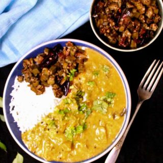 Green tomato dal in bowl with rice and sabzi on the side.