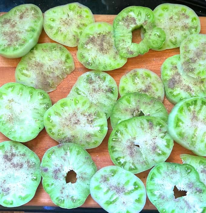 Sliced green tomatoes sprinkled with black pepper and salt.