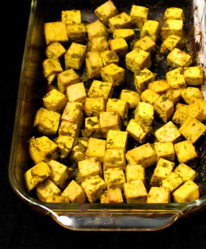 Baked tofu cubes in a glass baking dish.