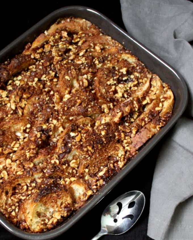 A top shot of a vegan french bake in a gray stoneware baking dish and a serving spoon on the side