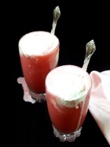 Two tall glasses of vegan watermelon smoothies topped with vanilla ice cream