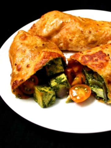 Vegetable Frankie made without eggs with a stuffing of spinach tofu cubes and cherry tomatoes