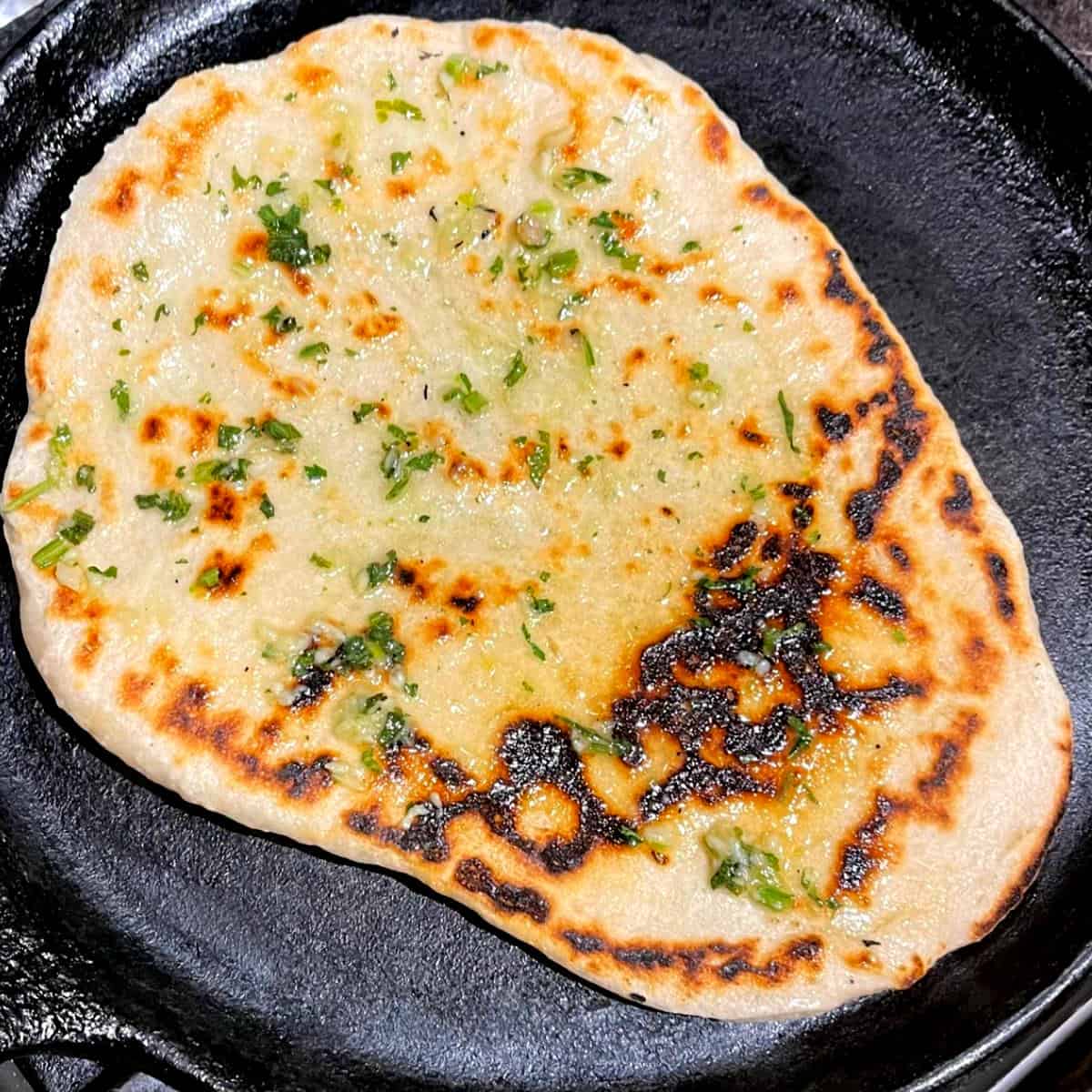 Vegan naan cooked on griddle.