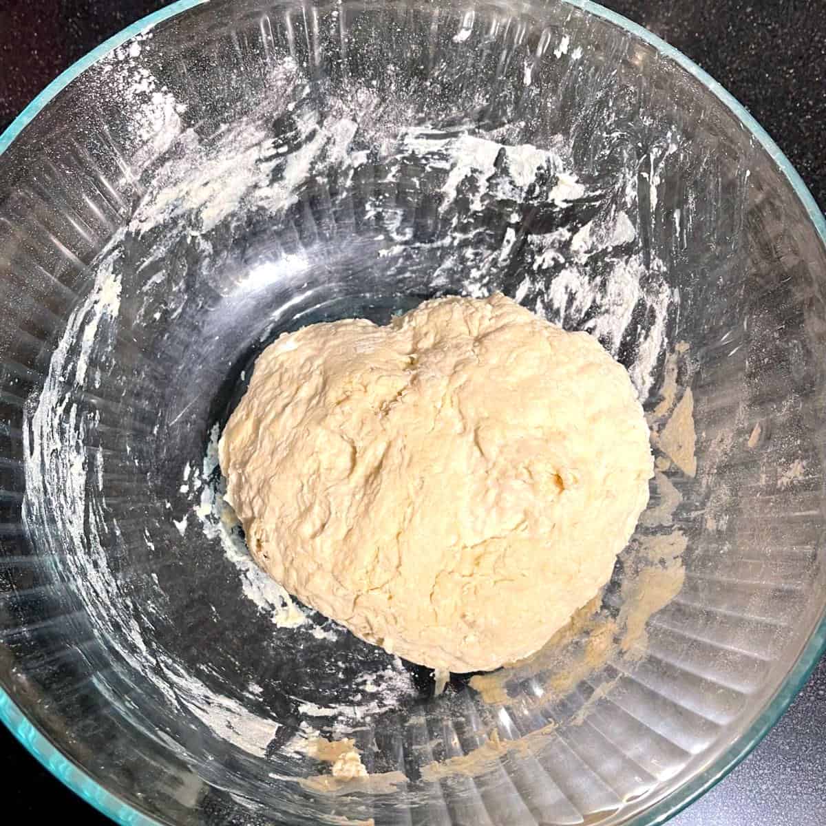 Vegan naan dough mixed in glass bowl.
