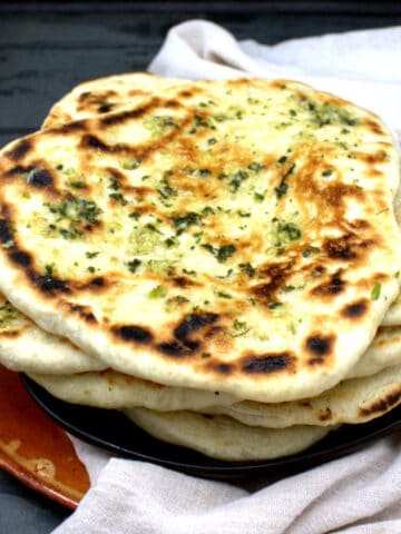 Vegan naan on plate with garlic butter topping.