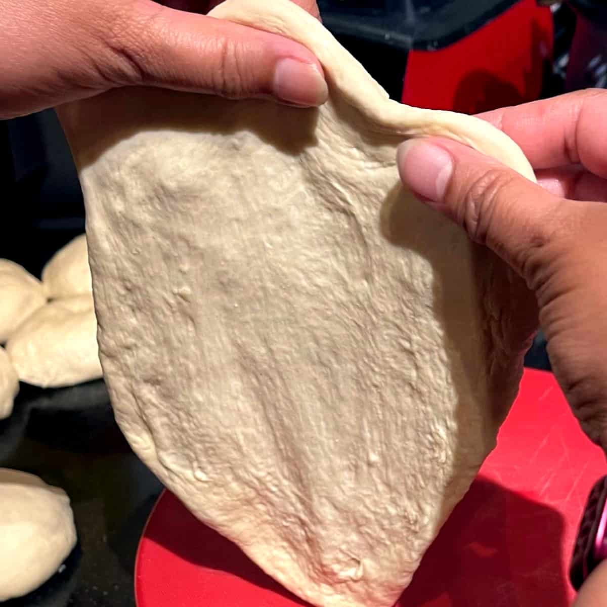Shaping vegan naan with fingers.