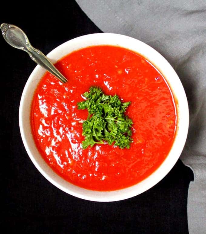 Marinara sauce in white bowl with spoon.