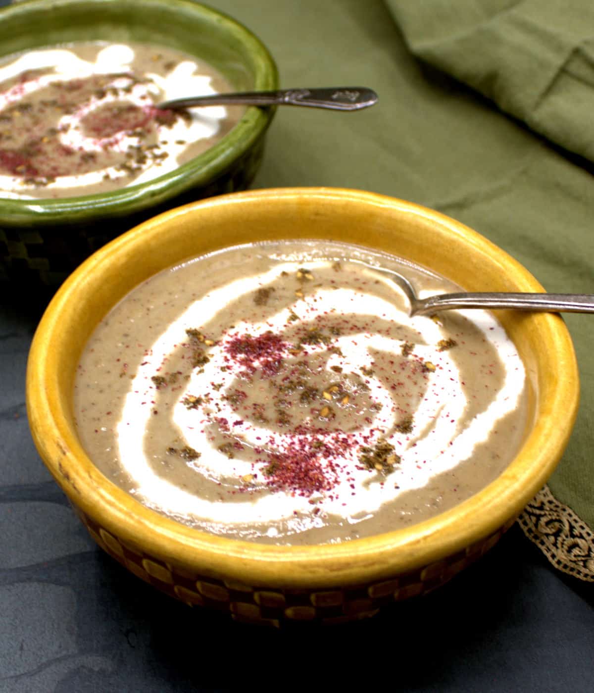 Creamy eggplant soup with cashew cream and za'atar in bowls.