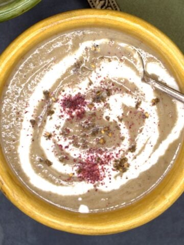 Roasted eggplant soup in bowl with cashew cream and za'atar.