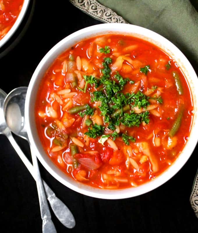 Top shot of a bowl of vegan minestrone soup, a thick Italian soup with beans, pasta and veggies