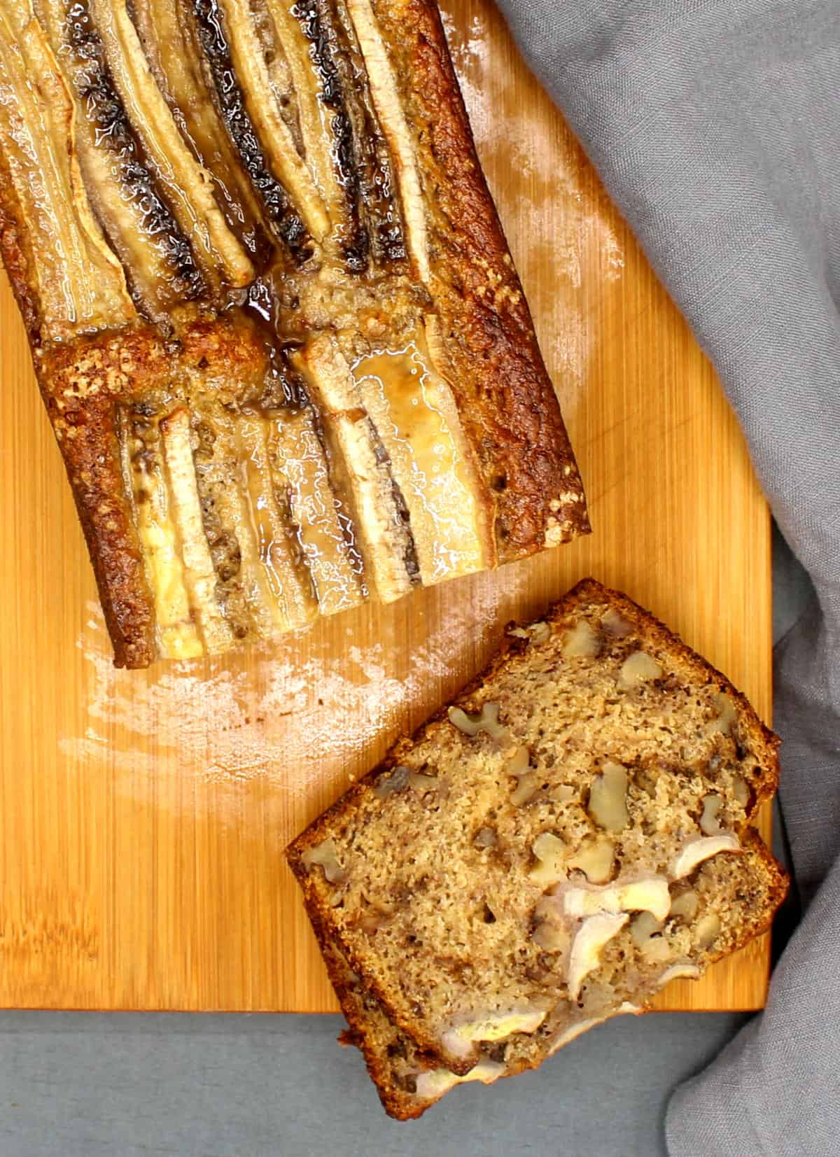 Eggless banana bread, sliced, on a chopping board.