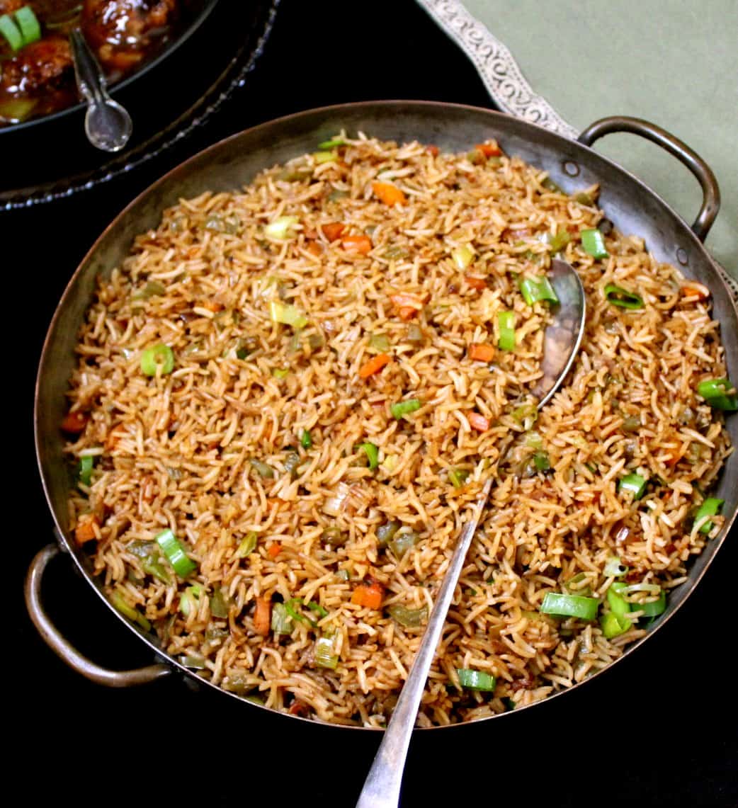 An overhead-front shot of a large copper server with Indo-Chinese veg fried rice