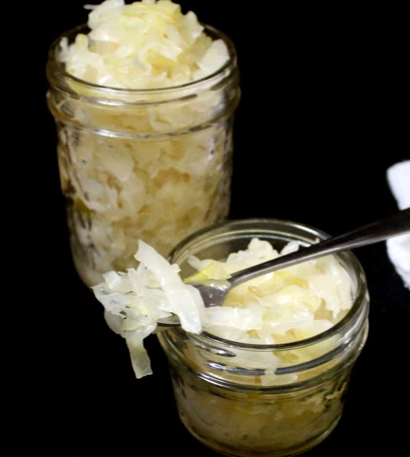 Two jars of sauerkraut with a fork