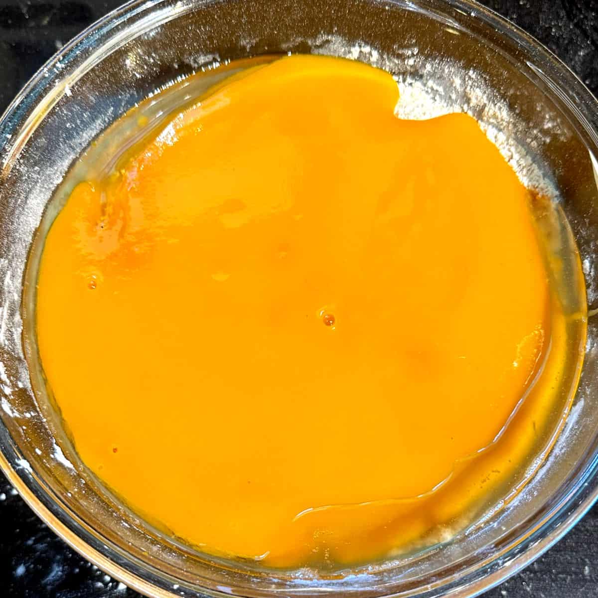 Mango puree and oil added to bowl.