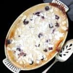 An overhead shot of vegan cherry clafoutis made with tofu with a silver cake server