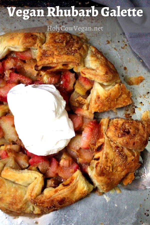 An easy vegan rhubarb galette baked on a baking sheet with puff pastry and topped with vegan whipped cream