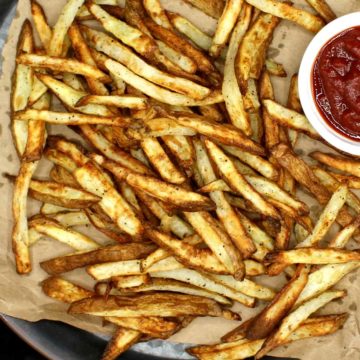 These Air Fryer French Fries are perfection itself. They turn out all crispy and delicious in an air fryer with a minimal quantity of oil. If you want an even healthier, no-oil option, I've got you covered as well. #frenchfries, #airfryer, #lowfat | HolyCowVegan.net