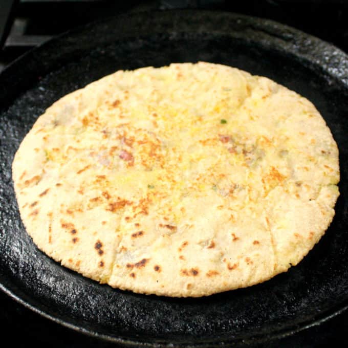 Aloo Paratha roasting on a cast iron griddle
