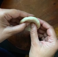 Dough being shaped in hands for kachori cover.