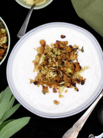 Make this creamy vegan Cauliflower soup with a crunchy and herby breadcrumb topping to satisfy that urge for something warm and comforting in your belly as the leaves turn brown and the weather begins to bite. A soy-free recipe, can be nut-free and gluten-free. #vegan, #soup, #cauliflower, #glutenfree | HolyCowVegan.net