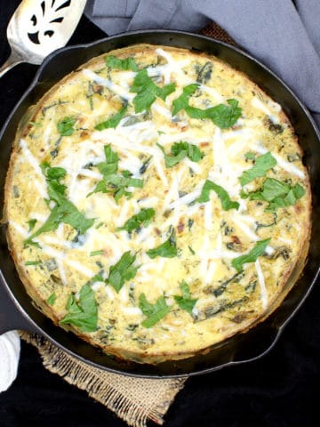 Here's a simple vegan Leek and Spinach Frittata with fresh leeks and spinach wrapped in a savory, creamy, herby custard of tofu and vegan cheese. It's a delicious, protein-packed meal you can devour any time of day. A nut-free and gluten-free recipe. #vegan, #frittata, #eggless, #veggies | HolyCowVegan.net