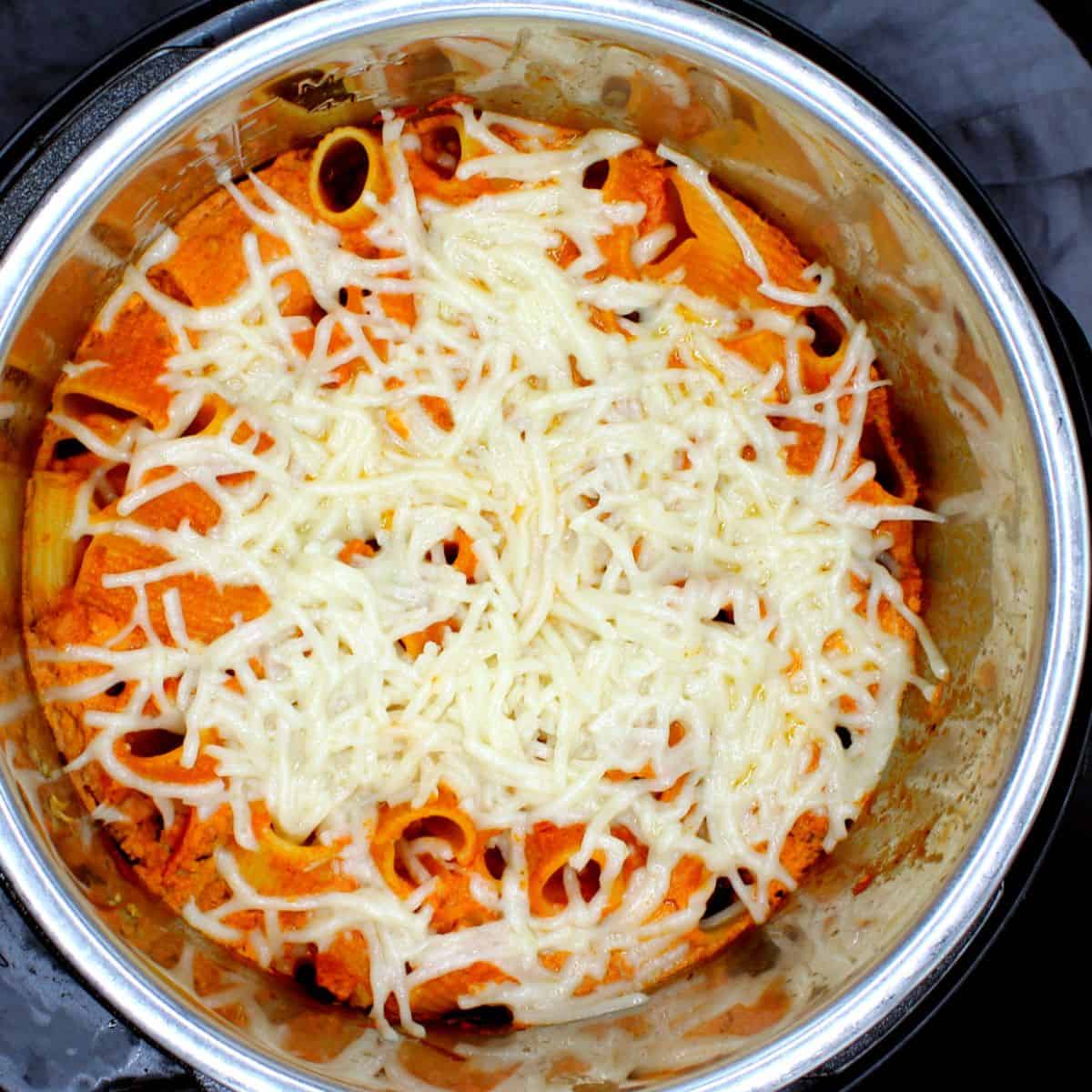 Cheesy vegan pasta bake in Instant Pot liner with vegan mozzarella on top.