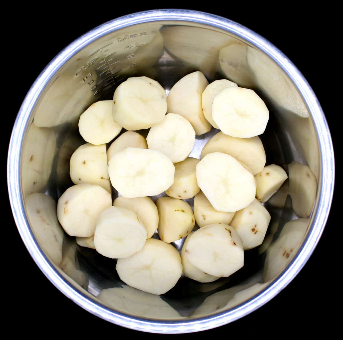 Halved peeled potatoes in Instant Pot liner.