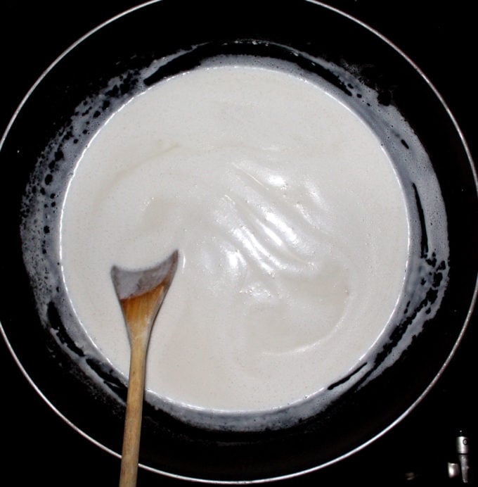 Vegan rabri reducing in a large, gray wok