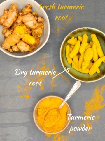 Bowls with dry turmeric root, turmeric powder and fresh turmeric root.