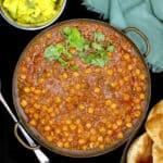 Chana masala recipe with side of poori and potato curry.
