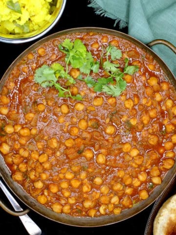 Chana masala recipe with side of poori and potato curry.