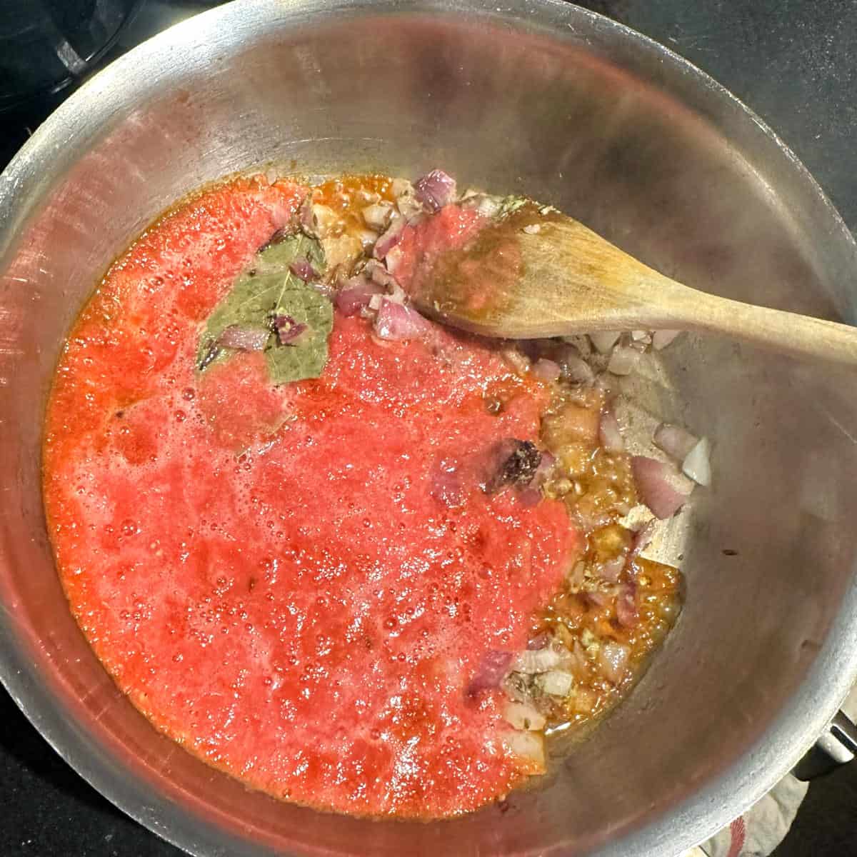 Tomato puree added to pot.