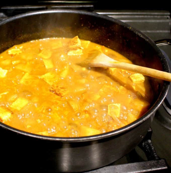 Curry with Jamaican spices simmering on stove.