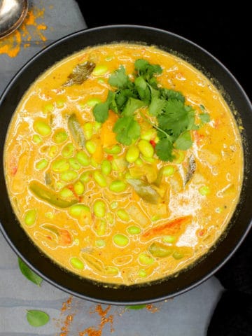 easy, spicy edamame curry in a black bowl with garam masala and cilantro