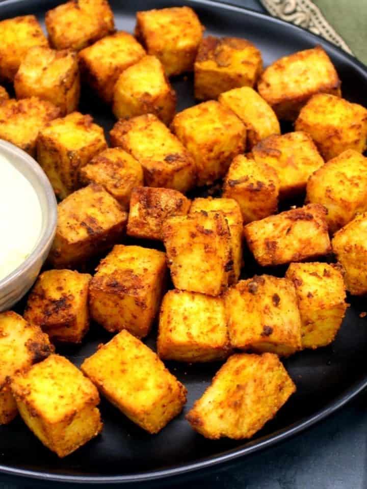 Crispy air fryer tofu cubes baked in an air fryer with a bowl of vegan mayo