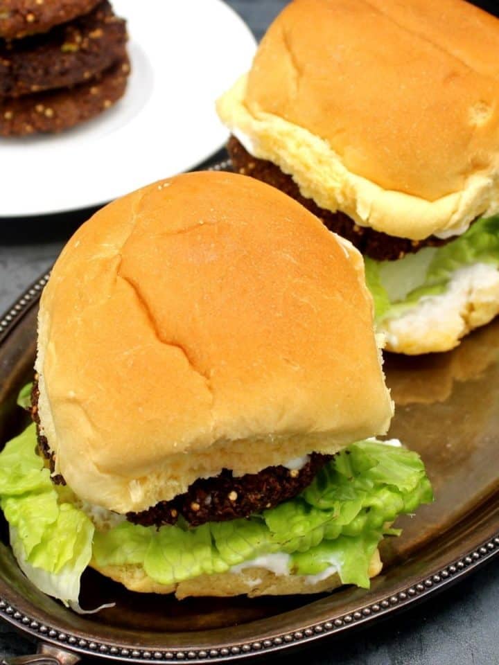 Photo of falafel burgers with mayo and lettuce on a silver tray