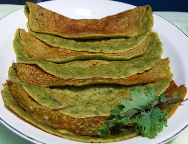Photo of kale crepes in a white platter with greens.