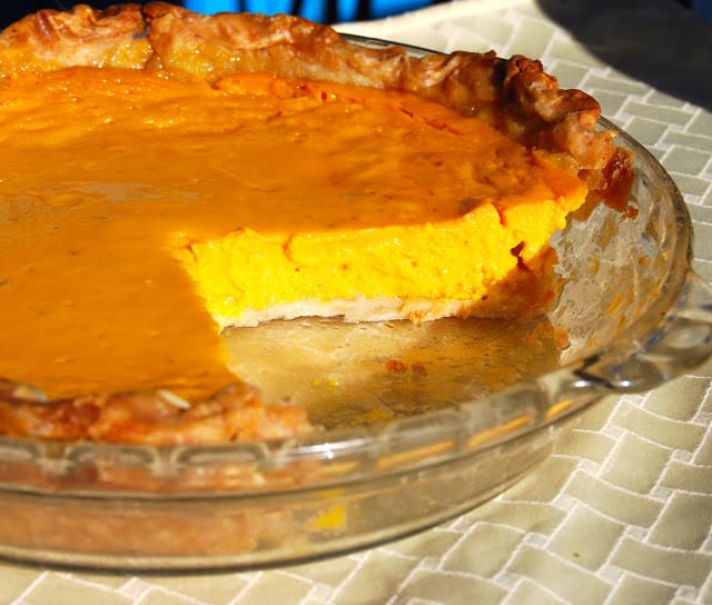 Vegan Mango pie, with a slice cut out, in glass baking dish.