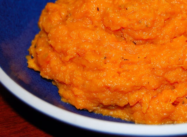 Photo of vegan mashed orange sweet potatoes in a blue bowl.
