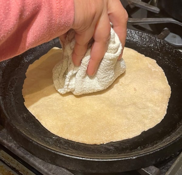 Photo of a roti on a cast iron griddle being cooked