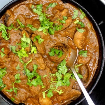 Authentic mushroom curry in bowl with spoon.