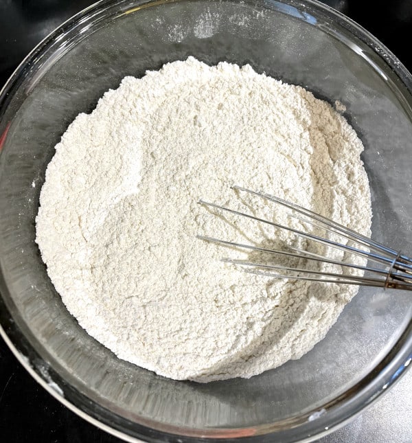 Flour whisked with baking soda and baking powder in bowl.