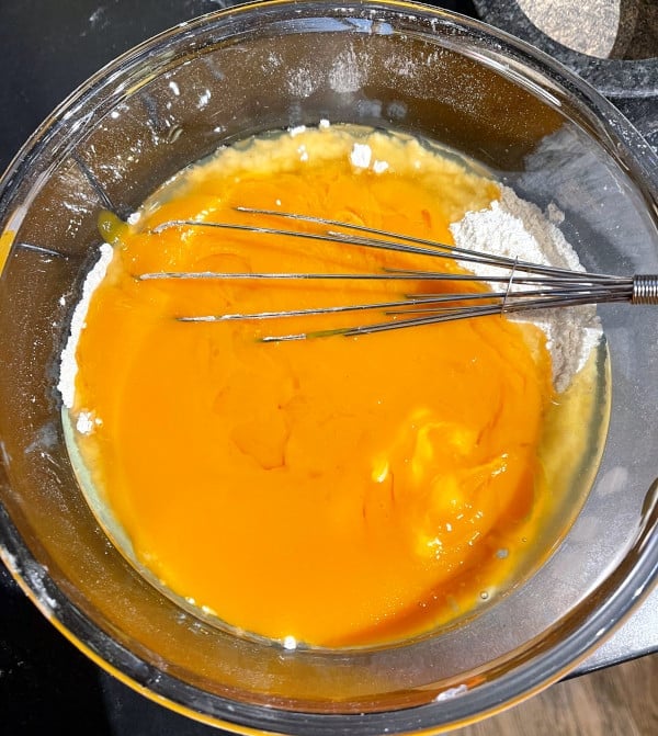 Bowl with mango puree mixed into flour.