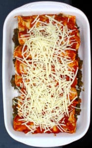 Vegan enchiladas with lentils in baking pan with shredded vegan cheese on top.