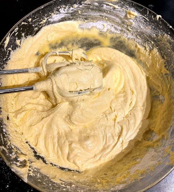 Mango cake batter being mixed in bowl.